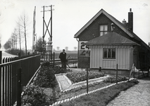 169410 Afbeelding van overwegwachter G.D. van de Broek in zijn tuin met tulpen bij de wachterswoning nr. 24a aan de ...